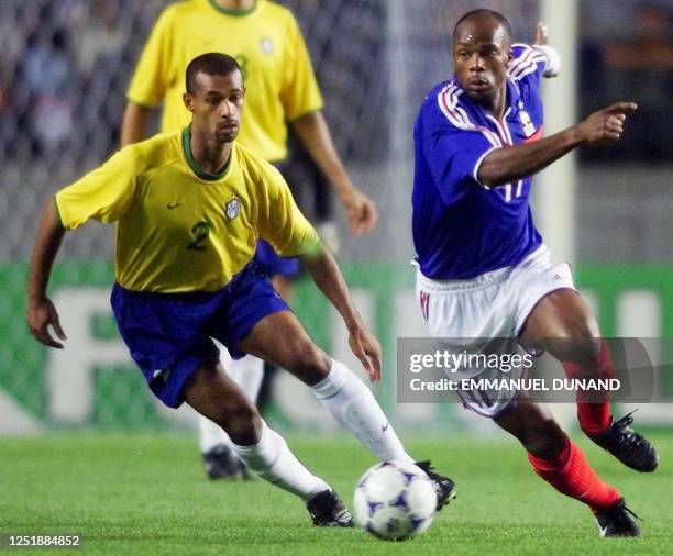 France's Sylvain Wiltord passes by Brazil's Ze Maria with the ball during the FIFA's Confederations Cup match in Suwon, 45km south of Seoul, 07 June...