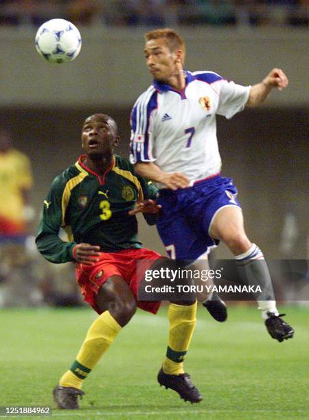 Japanese midfielder Hidetoshi Nakata jumps to battle the ball wtih Cameroon defender Pierre Wome during the preliminary round match of the FIFA...