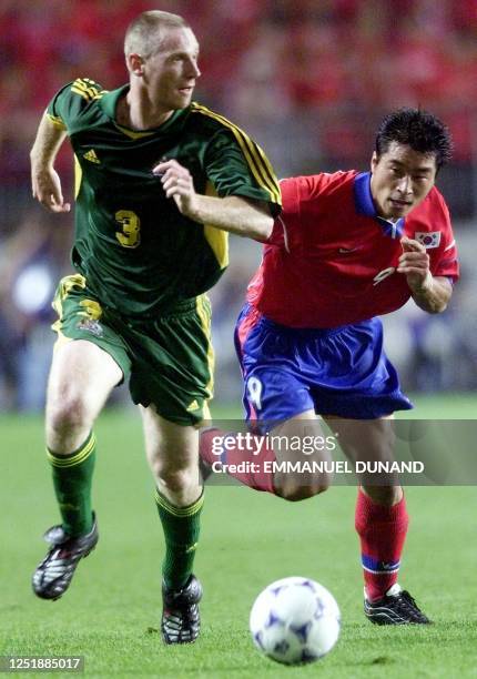 Australian football player Craig Moore and South Korea's Kim Do-Hoon race for the ball 03 June 2001 during the group A match of the FIFA...