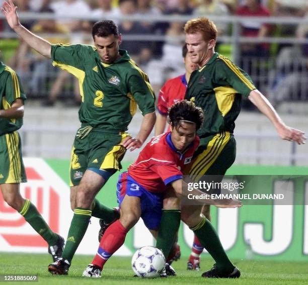South Korean player Choi Sung-Yong tries to drive the ball between Australia's Kevin Muscat and Hayden Foxe 03 June 2001 during the first group A...