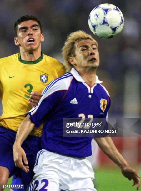 Brazilian player Lucio and Takayuki Suzuki of Japan fight for the ball during their FIFA's Confederations Cup match in Kashima, 100km north of Tokyo,...