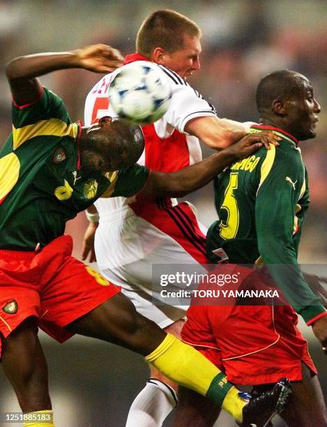 Cameroon midfielder Geremi Njitap and defender Raymond Kalla battles for the ball with Canadian defender Jason Devos during the preliminary round...