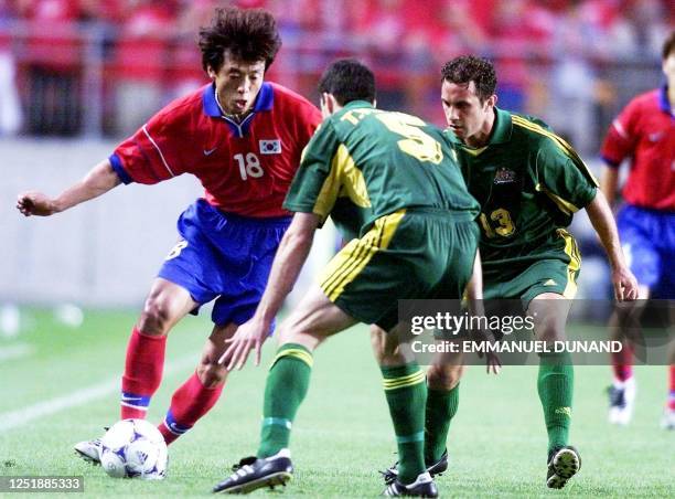 South Korean football player Hwang Sun-Hong drives the ball past Australia's Tony Vidmar and Marco Bresciano 03 June 2001 during the first group A...