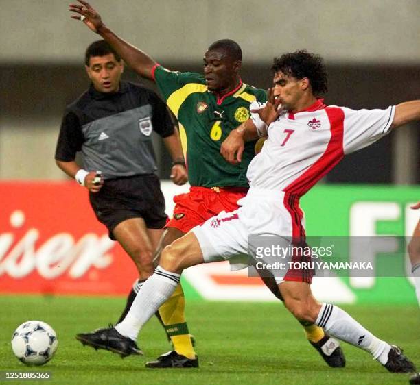 Cameroon defender Pierre Njanka battles with Canadian midfielder Paul Stalteri during a preliminary round match of the FIFA Confederations Cup in...