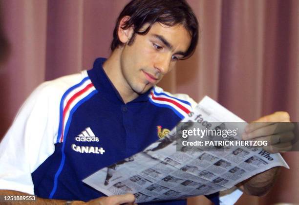 French midfielder Robert Pires reads a sports newspaper during a press conference prior a practice session of the French team, at Bob Jane stadium in...