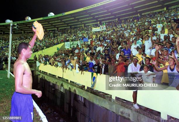 Soccer player Denilson offers his shirt to his fans after winning the game in Sao Luis, Brazil 14 November 2001. El brasileno Denilson, jugador del...
