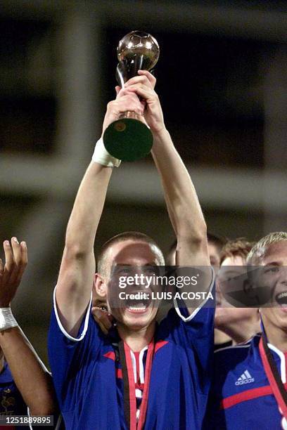 France's Anthony Letallec of the Sub-17 team celebrates 30 September as he holds the World Cup trophy in Port of Spain, Trinidad and Tobago. France...