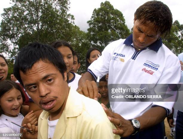 Hondurian soccer player Carlos Alberto Pavon signs an autograph for a student from the "Juana Leclerc" institute for the disabled in Tegucigalpa on...