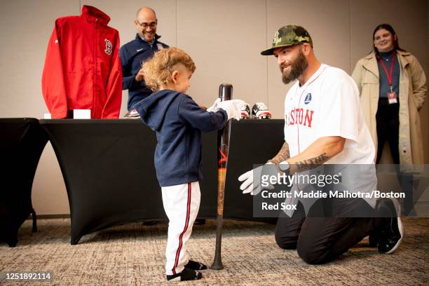 Former Boston Red Sox player Jonny Gomes shows his son his bat from the Baseball Hall of Fame during a game between the Los Angeles Angels and the...