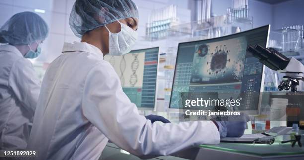 covid-19 - laboratory team working on coronavirus vaccine. protective workwear - research stock pictures, royalty-free photos & images