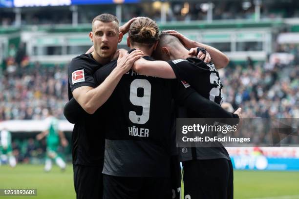 Lucas Hoeler of SC Freiburg celebrates his goal with Maximilian Eggestein of SC Freiburg and Roland Sallai of SC Freiburg during the Bundesliga match...