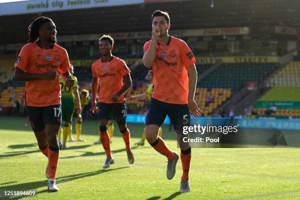 Michael Keane of Everton celebrates with Alex Iwobi after scoring his team's first goal during the Premier League match between Norwich City and...