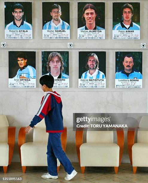 Boy walks past pictures of Argentine football national team members at J-Village at Hirono and Naraha in Fukushima Prefecture, some 200 km north of...