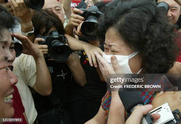 Recovered Severe Acute Respiratory Syndrome patient Hong Yu reacts upon seeing family members after being released from the Xiaotangshan SARS...