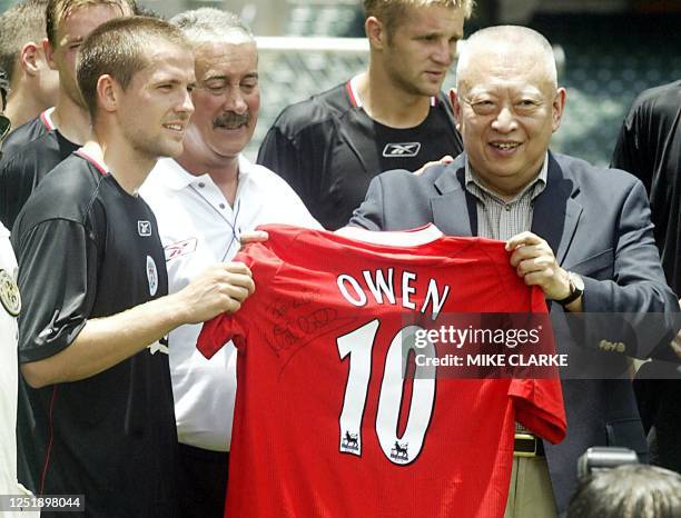 Hong Kong Chief Executive Tung Chee-hwa receives a signed jersey from Liverpool player Michael Owen prior to the team's training in Hong Kong...