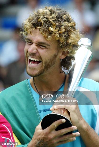 Brazilian Gustavo Kuerten smiles with his his trophy after winning the final over Dominik Hrbaty in straight sets, 6-3, 7-5 at the Heineken Tennis...