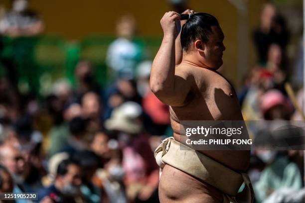Sumo wrestler warms up before the "votive grand sumo tournament", a ceremonial sumo exhibition, on the grounds of Yasukuni Shrine in Tokyo on April...