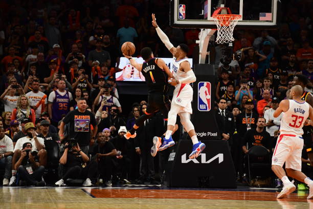 Russell Westbrook of the LA Clippers blocks the shot by Devin Booker of the Phoenix Suns, winning Round One Game One of the 2023 NBA Playoffs on...