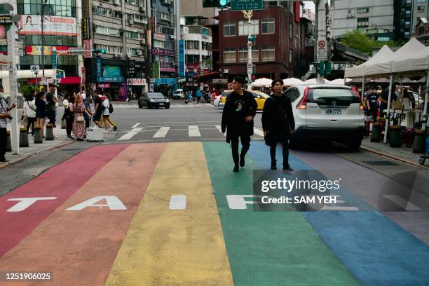 This picture taken on April 14, 2023 shows people walking down a street at the Ximen district in Taipei. - At a barbed-wire Taipei museum where...