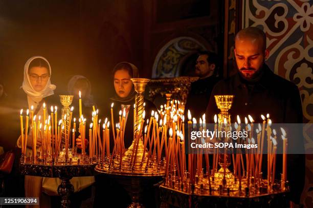 Ukrainian believers light candles during the Holy Sunday celebrations in St. Michael's Golden-Domed Monastery in central Kyiv. According to...