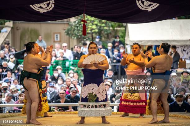 Sumo wrestlers sing after competing in the "votive grand sumo tournament", a ceremonial sumo exhibition, on the grounds of Yasukuni Shrine in Tokyo...