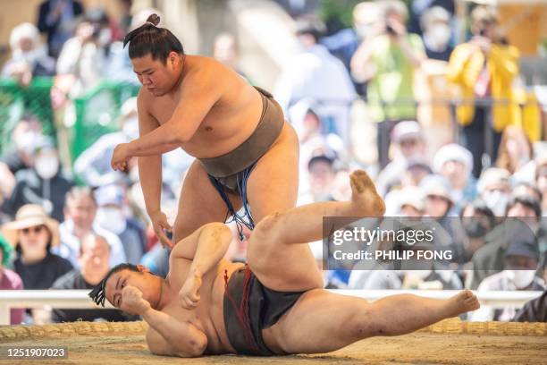 Sumo wrestlers compete during the "votive grand sumo tournament", a ceremonial sumo exhibition, on the grounds of Yasukuni Shrine in Tokyo on April...