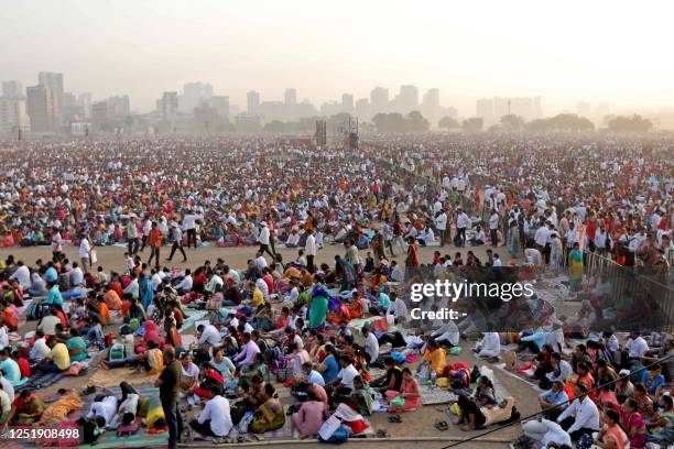 In this photograph taken on April 16 people gather to attend an award ceremony on the outskirts of Mumbai. - Heatstroke killed 11 people in India...