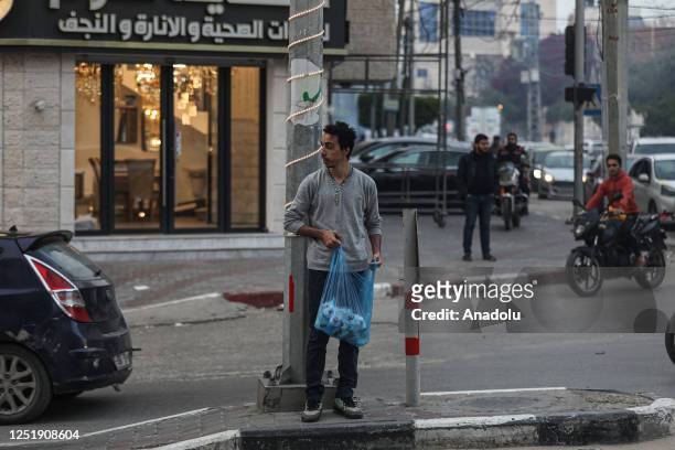 Year-old Palestinian Christian Ehab Ayyad offers water and dates to drivers stuck in traffic during holy month of Ramadan in Gaza City, Gaza on April...