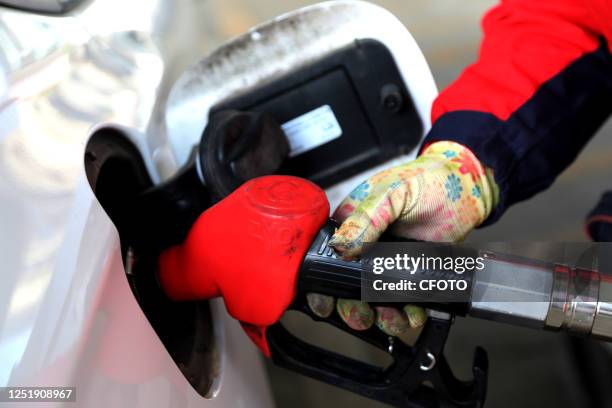 Staff member fills up a car at a gas station in Lianyun district of Lianyungang city, East China's Jiangsu province, April 17, 2023. The National...