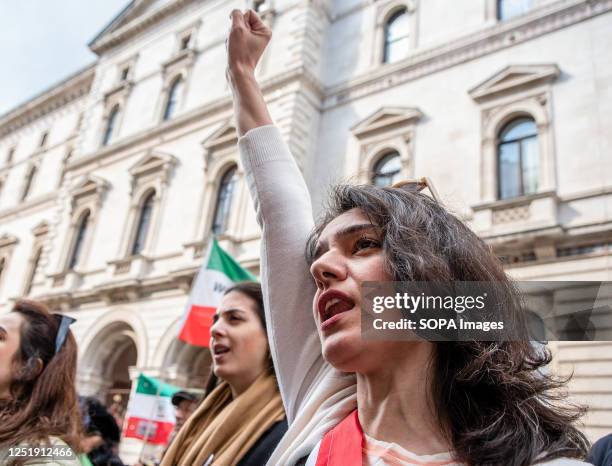 An Iranian woman chants slogans while making a fist outside of the Foreign Office during the protest. The Iranian people have been protesting since...