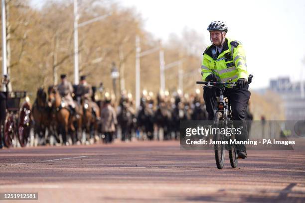 Police guide a procession along the Mall, central London, where preparations are underway for the coronation of King Charles III and the Queen...
