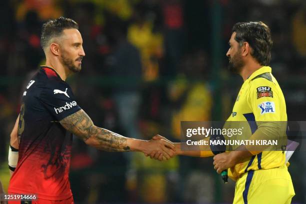 Royal Challengers Bangalore's captain Faf du Plessis shakes hands with his Chennai Super Kings' counterpart Mahendra Singh Dhoni before the start of...