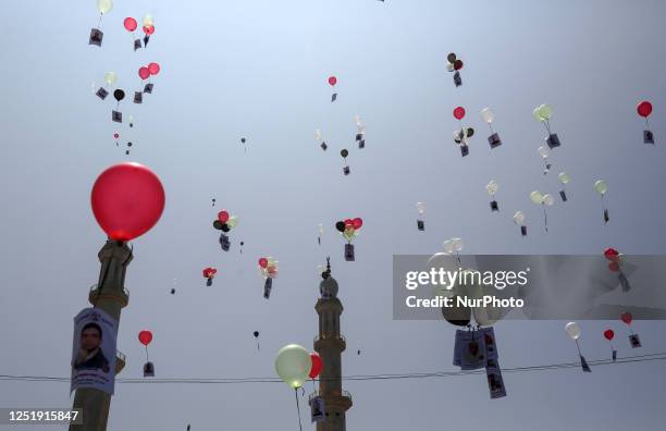 Balloons, with the portraits of Palestinians held in Israeli jails, are released during a gathering to commemorate Prisoner's Day, outside the...