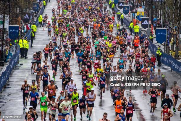 Thousands of runners make their way to the finish line during the 127th Boston Marathon in Boston, Massachusetts on April 17, 2023. - In wet and...