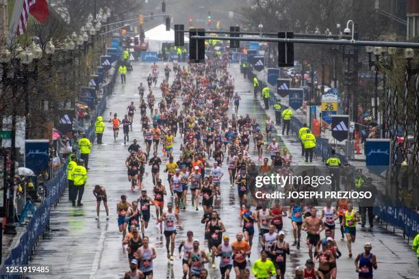 Thousands of runners make their way to the finish line during the 127th Boston Marathon in Boston, Massachusetts on April 17, 2023. - In wet and...