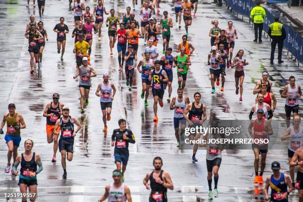 Thousands of runners make their way to the finish line during the 127th Boston Marathon in Boston, Massachusetts on April 17, 2023. - In wet and...