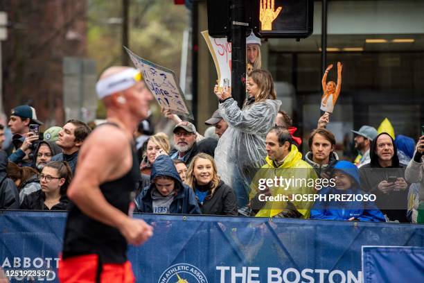 Spectators watch and cheer on runners during the 127th Boston Marathon in Boston, Massachusetts on April 17, 2023. - In wet and windy conditions,...