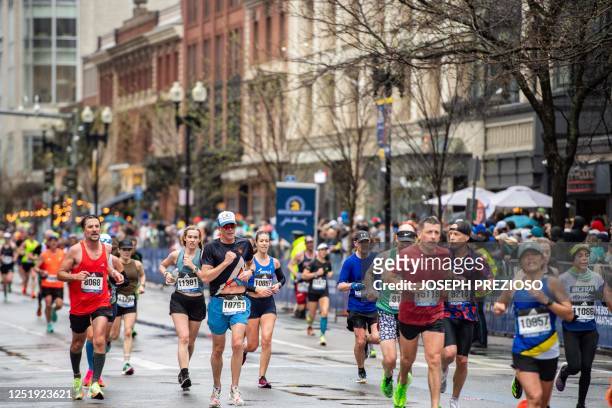 Runners make their way to the finish line during the 127th Boston Marathon in Boston, Massachusetts on April 17, 2023. - In wet and windy conditions,...