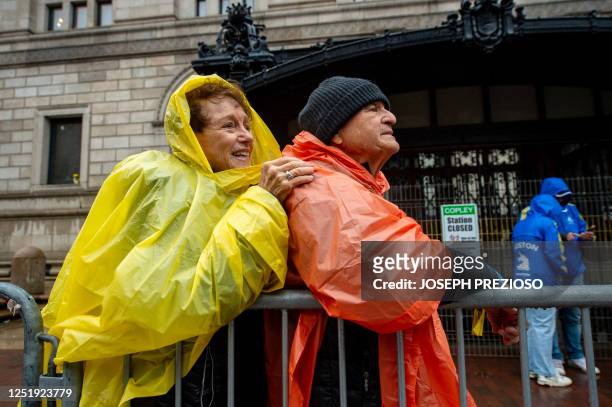 Spectators look to find a runner during the 127th Boston Marathon in Boston, Massachusetts, on April 17, 2023. - In wet and windy conditions, 2022...
