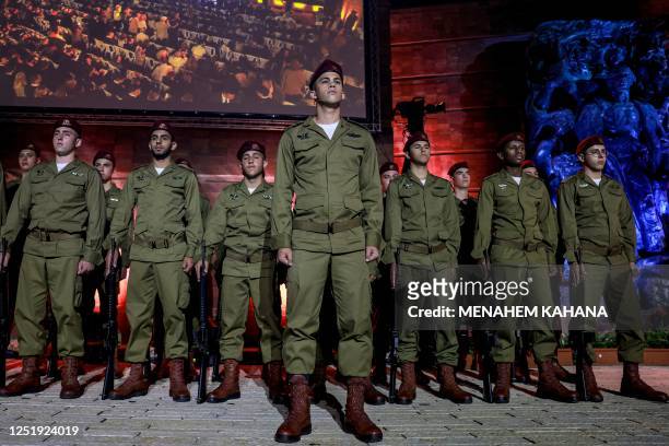 Israeli soldiers stand on stage during a ceremony marking Yom HaShoah, Holocaust Remembrance Day for the six million Jews killed during World War II,...