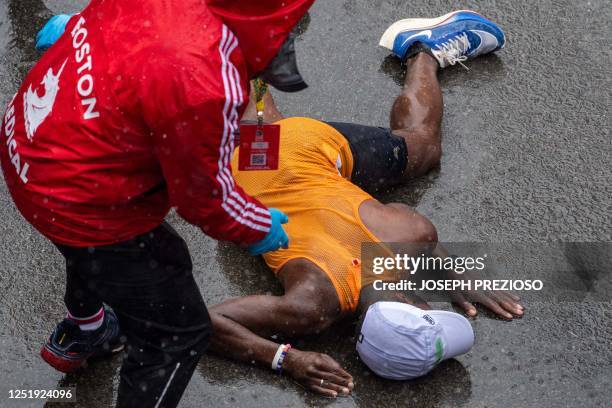 Runner collapses at the finish line during the 127th Boston Marathon in Boston, Massachusetts on April 17, 2023. - In wet and windy conditions, 2022...