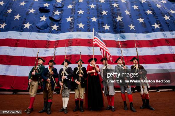 Members of the End Zone Militia display the colors as the American flag is dropped in front of the Green Monster before the Patriot's Day game...