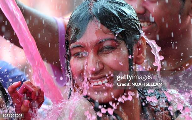 An Indian reveller enjoys artificial colored water during "Holi" celebrations in Hyderabad on March 20, 2011. The "Holi" festival of colours marks...