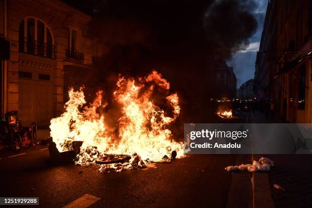 Demonstrators set a fire during a protest against the government and French President Emmanuel Macron's speech in Paris, on April 17 after pushing...