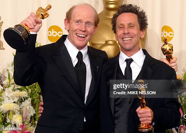 Director and producer Ron Howard and producer Brian Grazer hold their Oscar statues after winning the awards for best director and best picture for...