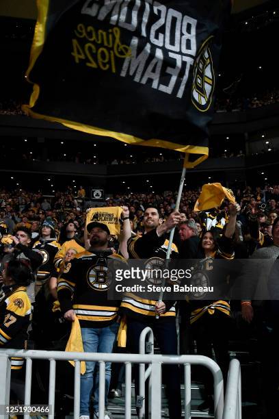 Alumni and current player development coordinator Adam McQuaid of the Boston Bruins waves the fan banner flag before the game against the Florida...