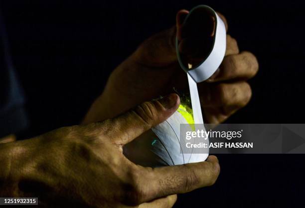 In this picture taken on April 7 a young cricketer wraps electric tape on the tennis ball before the start of the tape ball night cricket tournament...