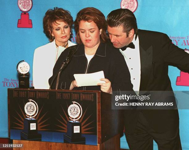 Raquel Welch and Alec Baldwin look over the shoulder of Rosie O'Donnell as she struggles with the pronunciation of one of the nominees for the 51st...