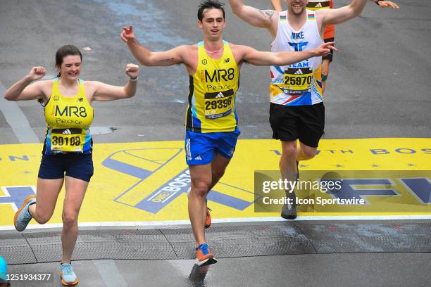 Liley Damatin and Henry Richard of Team MR8 cross the finish line of the 127th Boston Marathon on April 17, 2023 on Boylston Street in Boston, MA....