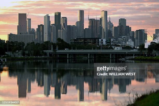 The Melbourne skyline in reflected in the Maribyrnong River in the early morning light on April 18, 2023. - Melbourne has officially become...
